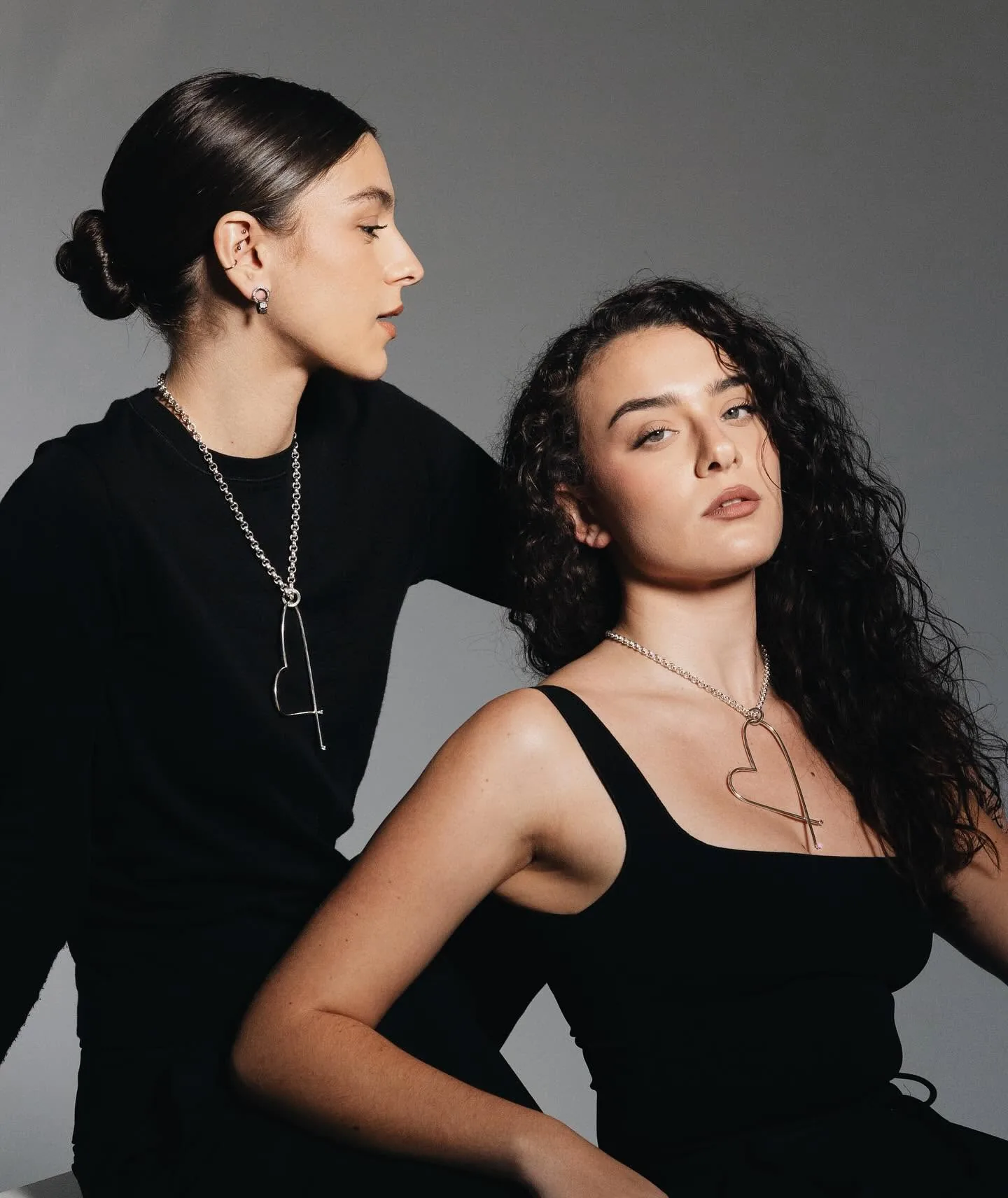 Two women wearing K.AND. necklaces in a studio portrait