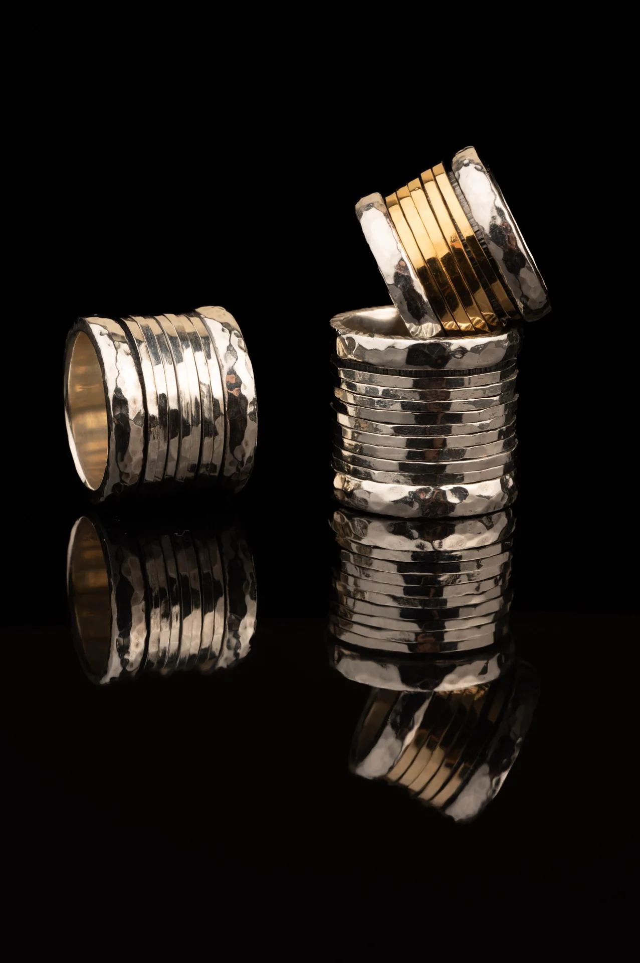 Tall stack of textured K.AND. rings on black
