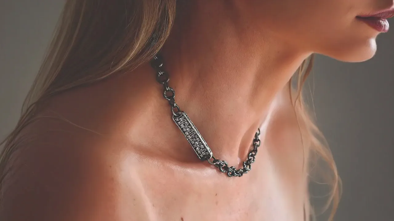 Orbit shot of a K.AND. pave bar chain worn on the neck (poster frame)